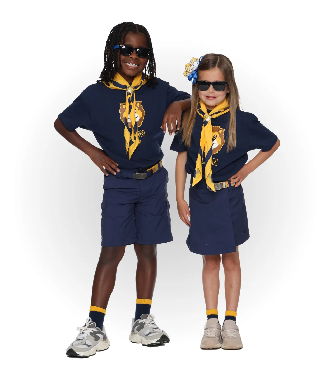 Two Lion Cub Scouts wearing navy Lion T-shirts with yellow neckerchiefs and navy uniform bottoms.